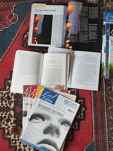 Literary magazines featuring published fiction and poetry by David Moran, spread across a table